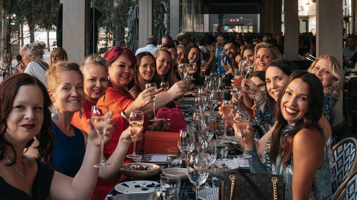 A long table of women raising a toast together